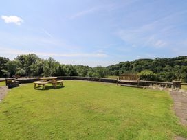 A garden with a table and bench at Coytrahen House near Bettws