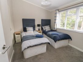 A bedroom with two single beds with bedside tables and a window at Lodge 2 in Auchterarder