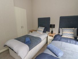 A bedroom with two single beds with blue headboards and chevron patterned pillows at Lodge 2 in Auchterarder