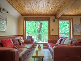 A living room with a sofa and table at Lodge 68 - Fern Gully near Finlakes Holiday Park
