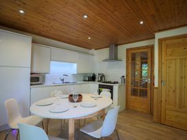 A kitchen with a table and chairs at Lodge 68 - Fern Gully near Chudleigh