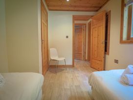 A bedroom with two beds and a chair at Lodge 68 - Fern Gully near Chudleigh