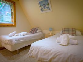 A bedroom with two beds and a nightstand at Lodge 68 - Fern Gully near Finlakes Holiday Park