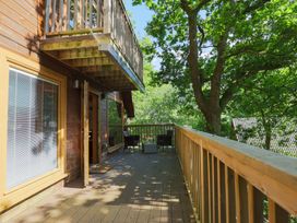 An outdoor deck with seating at Lodge 68 - Fern Gully near Finlakes Holiday Park