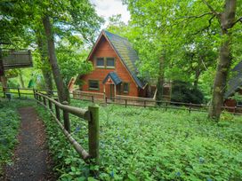 A house surrounded by trees and flowers at Lodge 68 - Fern Gully, Finlakes Holiday Park near Chudleigh