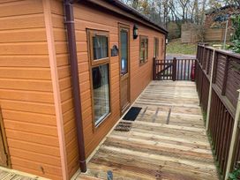 An outdoor area with a wooden cabin and deck at Woodland View 31 - The Hawthorns Finlakes Holiday Park near Chudleigh