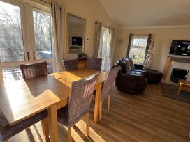 A living room with a dining table and a sofa at Woodland View 31 - The Hawthorns near Finlakes Holiday Park