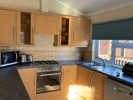 A kitchen with cabinets, appliances and a sink at Woodland View 31 - The Hawthorns near Chudleigh