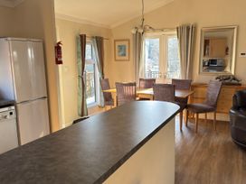 A kitchen with a refrigerator and dining area at Woodland View 31 - The Hawthorns Finlakes Holiday Park near Chudleigh