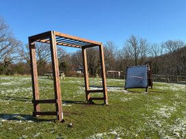 A swing frame and sandbox in an outdoor area at Woodland View 31 - The Hawthorns near Finlakes Holiday Park