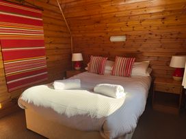 A bedroom with a bed, side tables and lamps at Tor View, Finlakes Holiday Park near Chudleigh