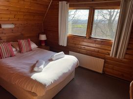 A bedroom with a bed and a window at Tor View in Finlakes Holiday Park near Chudleigh