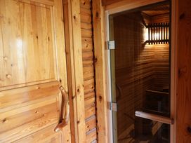 A sauna with wooden details and a glass door at Tor View Finlakes Holiday Park near Chudleigh
