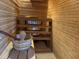 A sauna with wooden bench and bucket at Tor View Finlakes Holiday Park near Chudleigh
