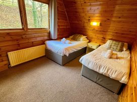 A bedroom with two beds and a bedside table at Tor View Finlakes Holiday Park near Chudleigh