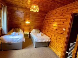 A bedroom with twin beds and a bedside table at Tor View near Finlakes Holiday Park Chudleigh