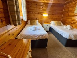 A bedroom with twin beds and a bedside table at Tor View Finlakes Holiday Park near Chudleigh