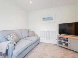 A living room with a sofa and TV at Glendale in Port Isaac