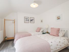 A bedroom with two beds and artwork on the walls at Glendale in Port Isaac