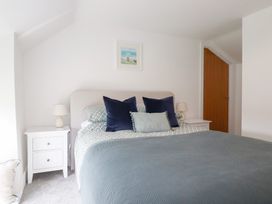 A bedroom with a bed and nightstands at Glendale in Port Isaac