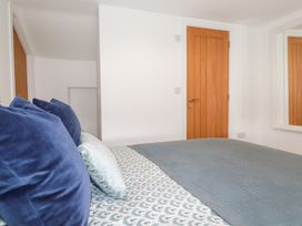 A bedroom with a bed and wooden door at Glendale in Port Isaac