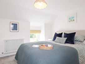 A bedroom with a bed and a window at Glendale in Port Isaac