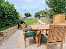 A garden with a wooden table and chairs at Glendale in Port Isaac