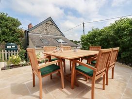 A dining table with chairs in the garden at Glendale in Port Isaac
