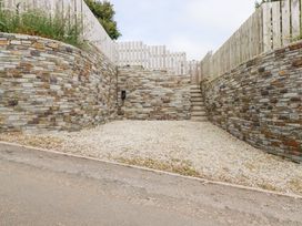 An outdoor area with stone walls and gravel ground at Glendale, Port Isaac