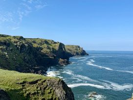 Cliffs by the ocean under a clear sky at Glendale Trelights near Port Isaac