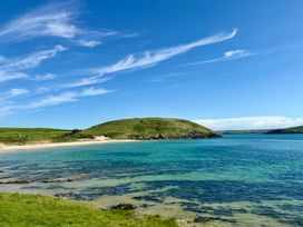 A beach with water and a hill at Glendale Trelights near Port Isaac