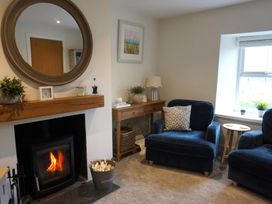 A living room with armchairs and a fireplace at Glendale Trelights near Port Isaac