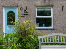 A door and window with plants and a bench at 1 Aberbeinw in Dolwyddelan