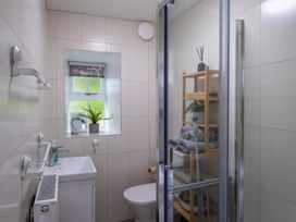 A bathroom with a shower, toilet and sink at 1 Aberbeinw in Dolwyddelan