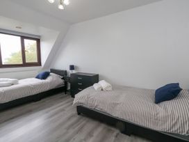 A bedroom with two single beds and a nightstand at The View in Weymouth