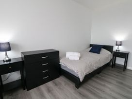 A bedroom with a bed, dresser and nightstands at The View in Weymouth