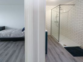 A bedroom with a bed and a shower area at The View in Weymouth