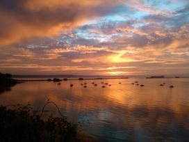 A sunset over water with boats docked at The View in Weymouth