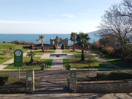 A garden with palm trees and a view of the sea at The View in Weymouth