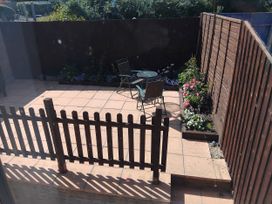 A garden with a table and chairs on paving stones at The View in Weymouth