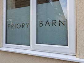 A close up of a window with frosted glass and the words PRIORY BARN on it