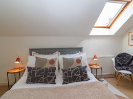 A bedroom with a bed and pillows under a skylight window at Priory Barn Apartment in Walton near Street