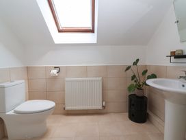 A bathroom with a toilet sink radiator plant and skylight at Priory Barn Apartment in Walton near Street