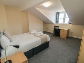 A bedroom with a bed and desk at The Newborough Apartment 5 Scarborough