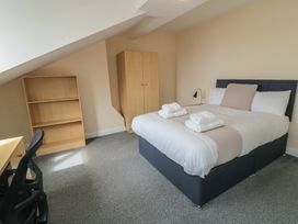A bedroom with a bed and a desk at The Newborough Apartment 5 Scarborough