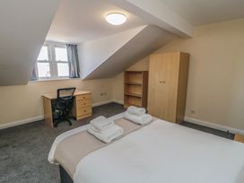 A bedroom with a bed and desk at The Newborough Apartment 5 Scarborough