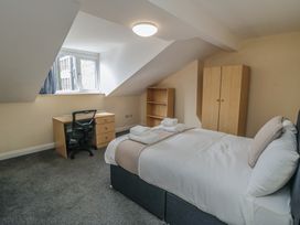 A bedroom with a bed, desk, and storage units at The Newborough Apartment 5 in Scarborough