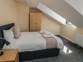 A bedroom with a bed and wardrobe at The Newborough Apartment 5 Scarborough
