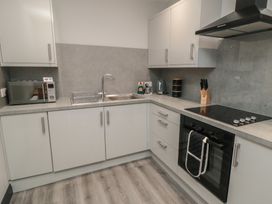 A kitchen with modern appliances and fixtures at The Newborough Apartment 1 Scarborough