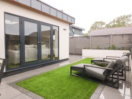 An outdoor space with sliding doors and patio chairs at Lodge in Llangefni